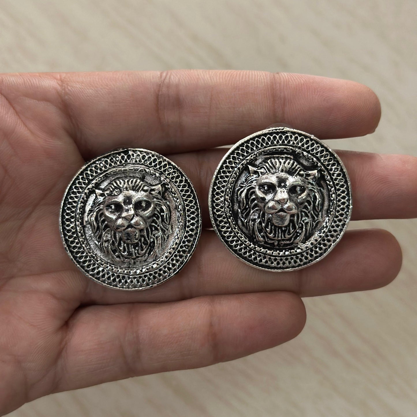 Oxidized round earrings with bold lion face design.
