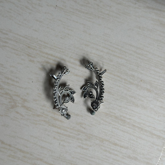 Oxidized ear cuffs with intricate floral and swirl detailing.