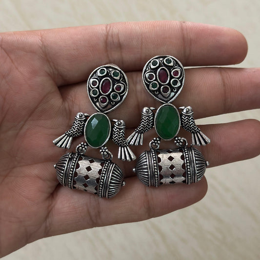 Oxidized silver earrings with bird motifs and green stone accents.