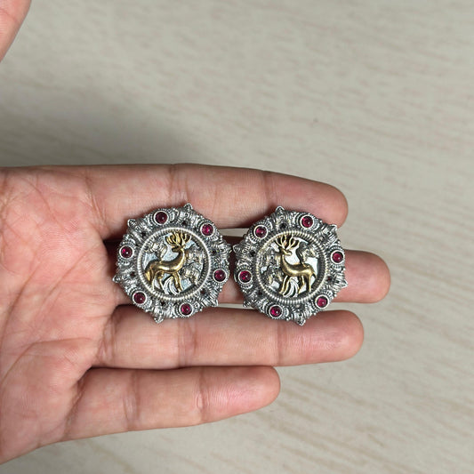 Oxidized round earrings with golden deer motif and red stone accents.