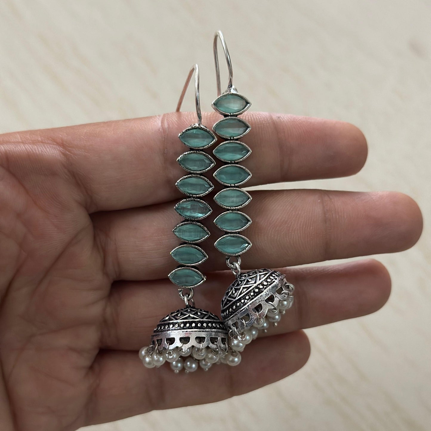 oxidized silver jhumka earrings featuring mint green stones and delicate pearl hangings