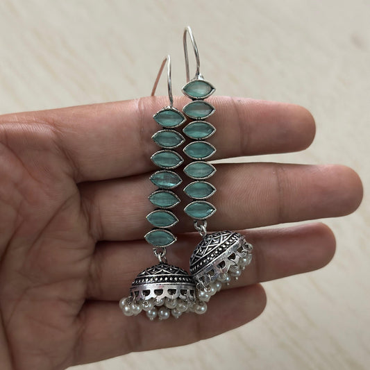 oxidized silver jhumka earrings featuring mint green stones and delicate pearl hangings