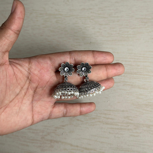 Oxidized silver floral jhumka earrings with white bead tassels.