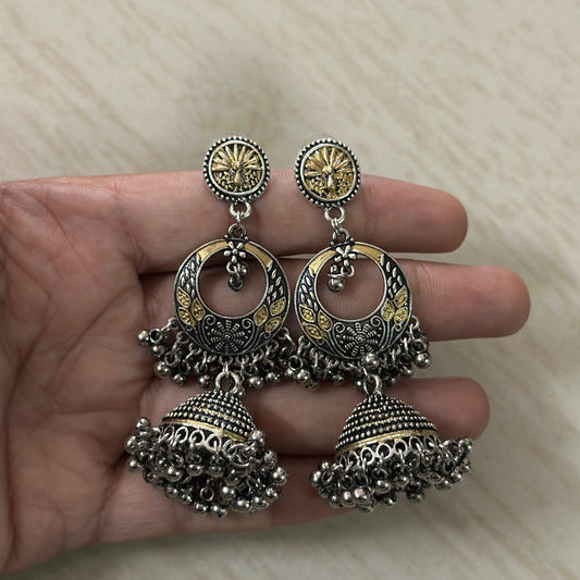 Oxidized silver jhumka earrings with dual-tone detailing and intricate peacock design.