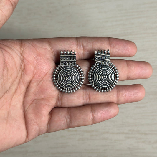 Bold oxidized silver earrings with tribal-inspired spiral and spiked detailing for a striking ethnic look.