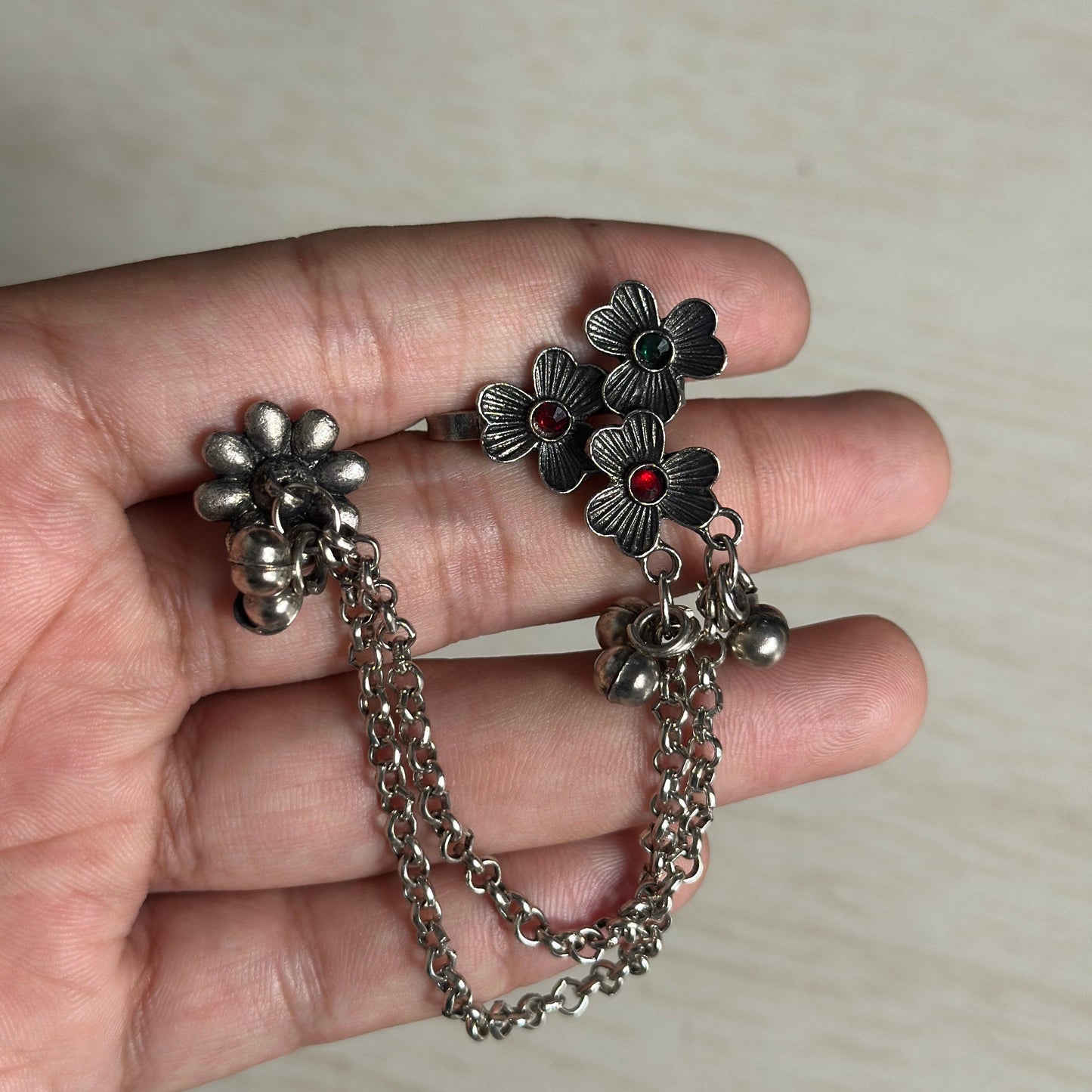 Oxidized floral ear cuff with dual chains, colored stones, and hanging ghungroos.