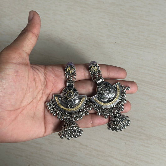 Oxidized silver earrings with intricate gold detailing and layered jhumka danglers.