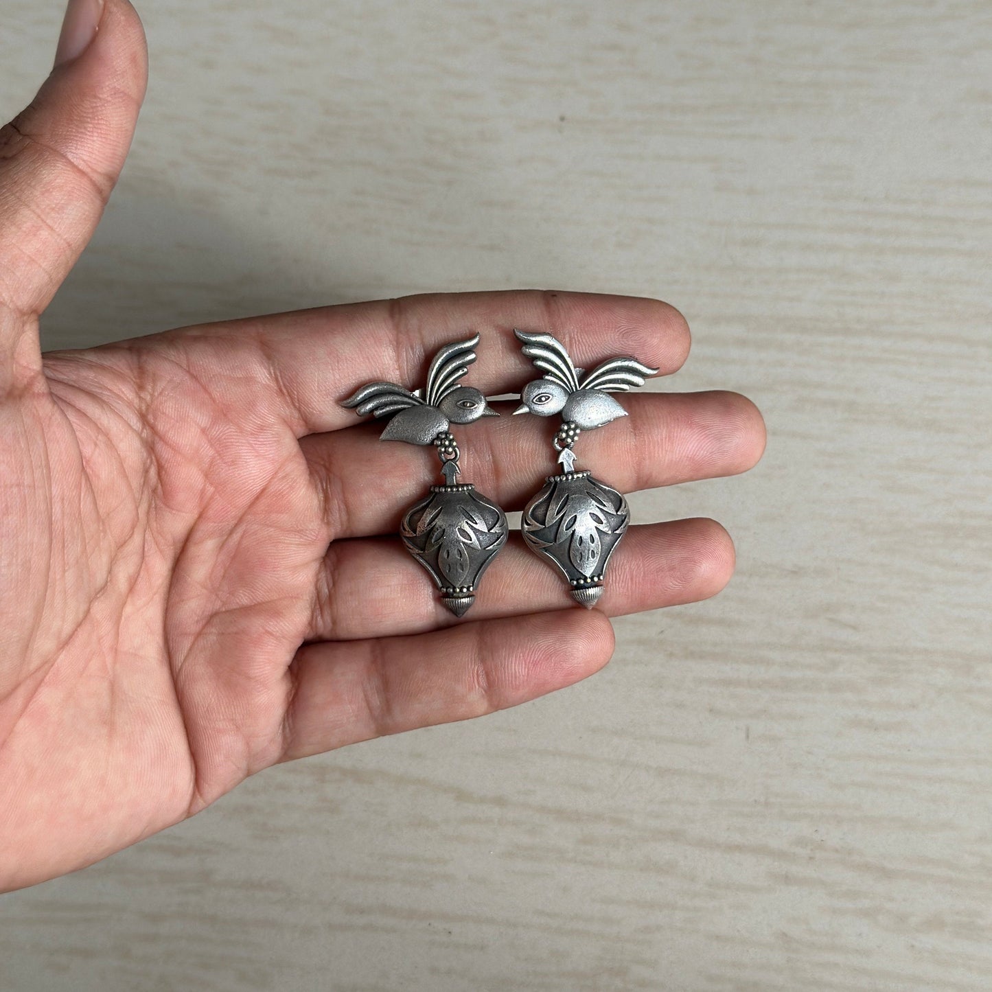 Oxidized silver earrings with bird motifs and engraved danglers.