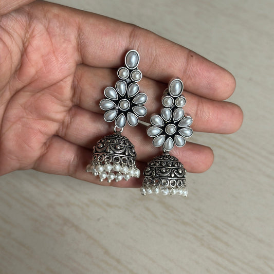 Oxidized silver jhumkas with pearl-studded floral tops and dome-shaped hangings.