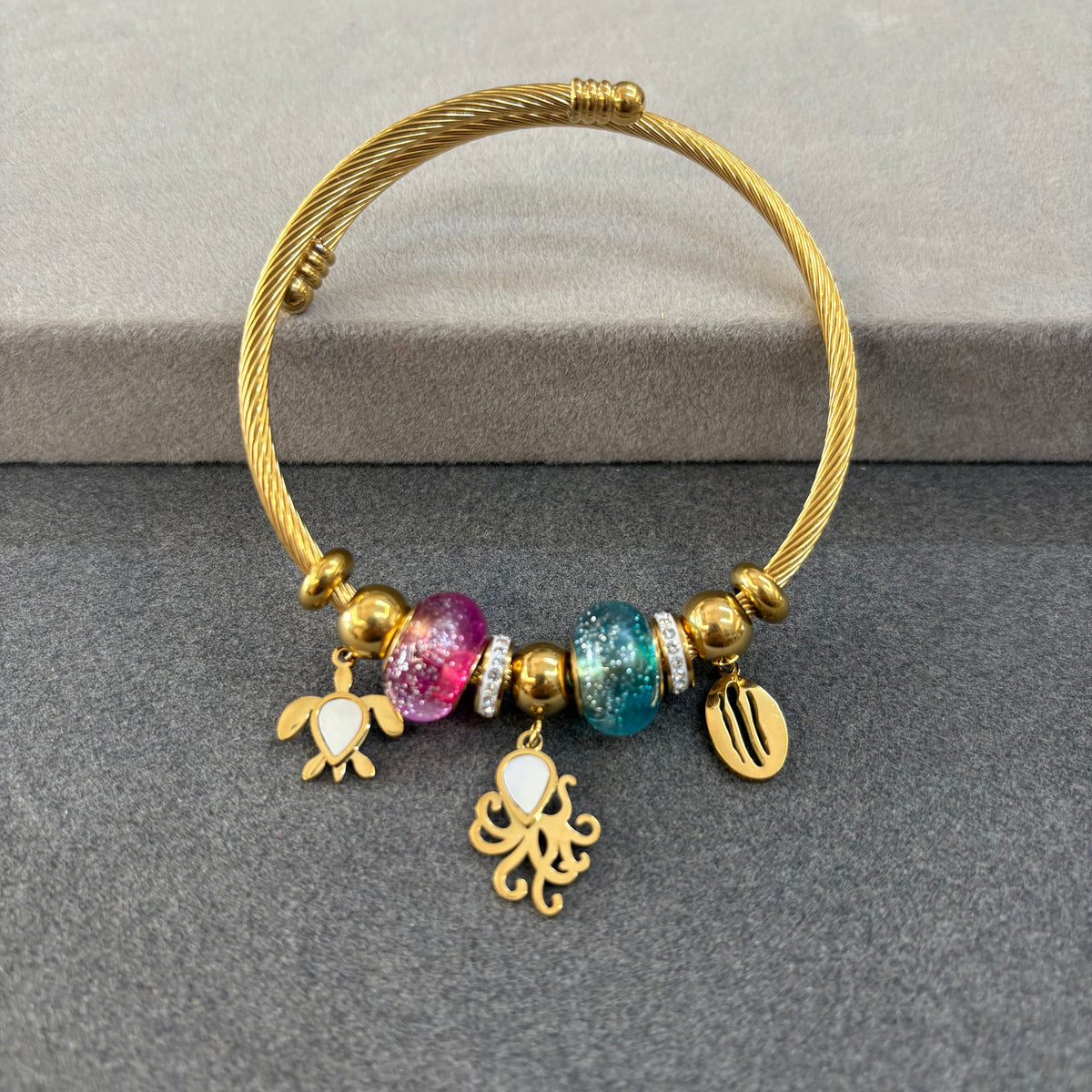 Gold-tone ocean-themed charm bangle bracelet