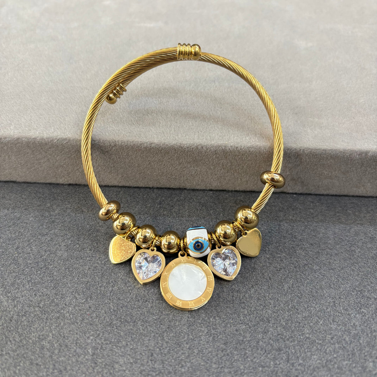 Gold-toned twist-cuff charm bracelet