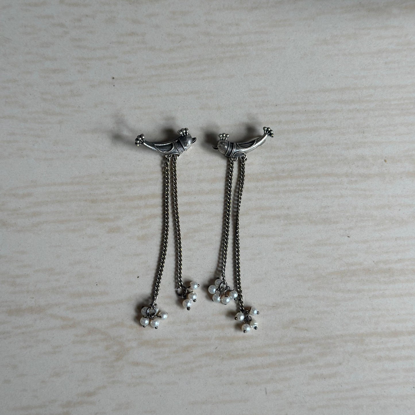 Oxidised silver earrings with fish design studs, dual chain drops, and tiny pearl hangings.